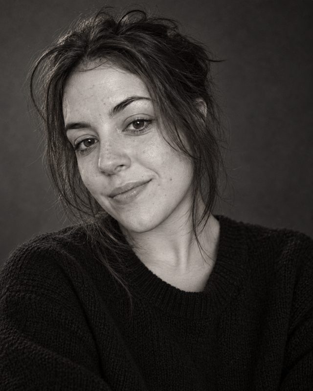 Example of the Classic black and white look: a black-and-white portrait of a woman with dark hair in a dark sweater against a plain backdrop