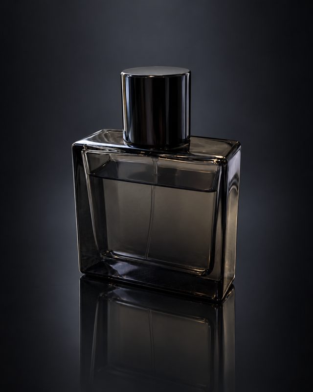 Example of the Mirror reflection look: a dark glass perfume bottle reflected on a black mirror surface