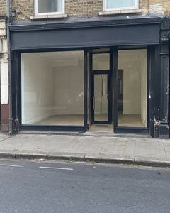 Example phone photo: an empty shop with a black front and bare windows