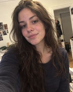 Example phone photo: a selfie of a woman with long dark hair in a dark top at home