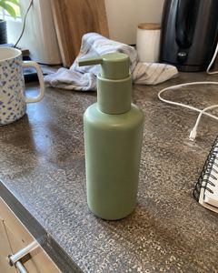 Example phone photo: a sage-green pump bottle on a cluttered kitchen counter