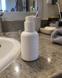Example phone photo: a white pump bottle on a bathroom counter beside the sink